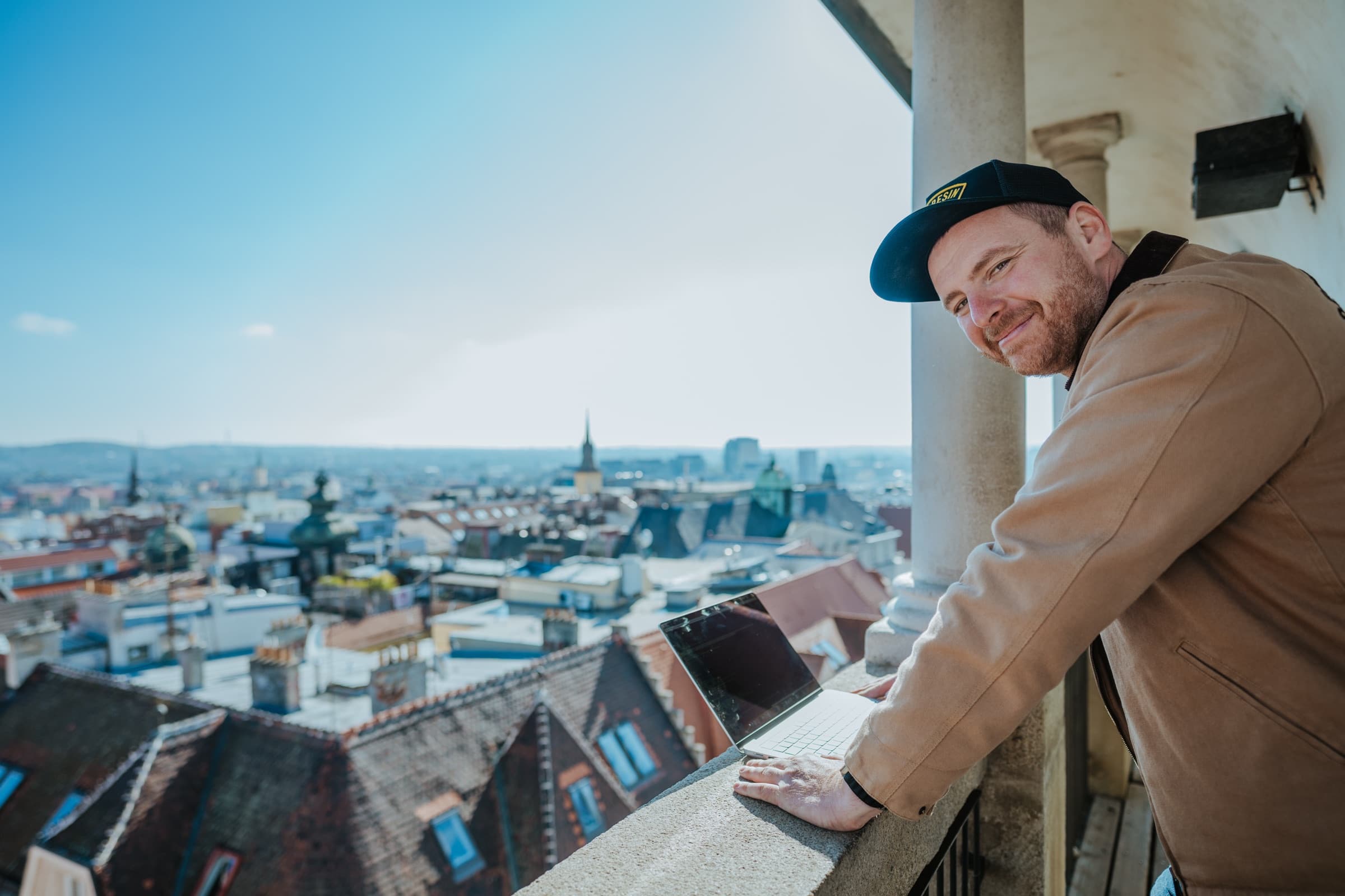 Jindřich Fáborský s notebookem nad střechami města